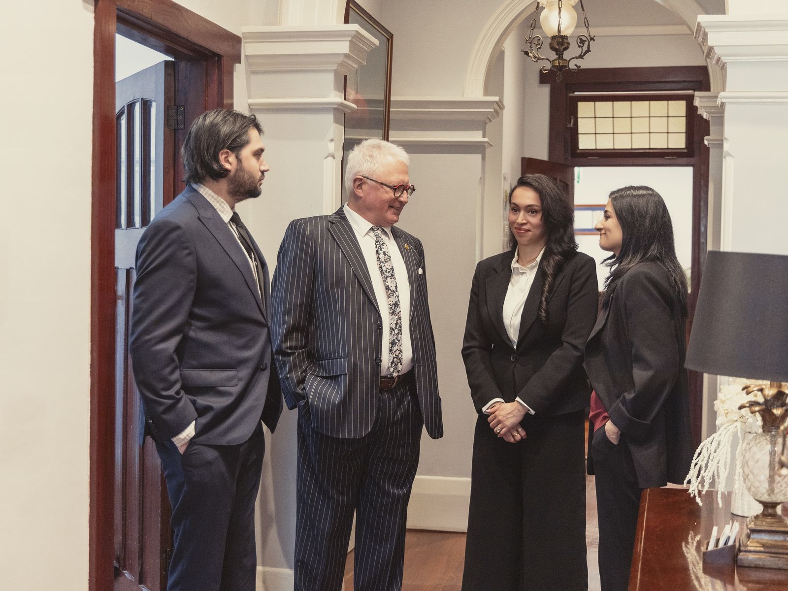 Steven M Clark in conversation with his team in the office hallway